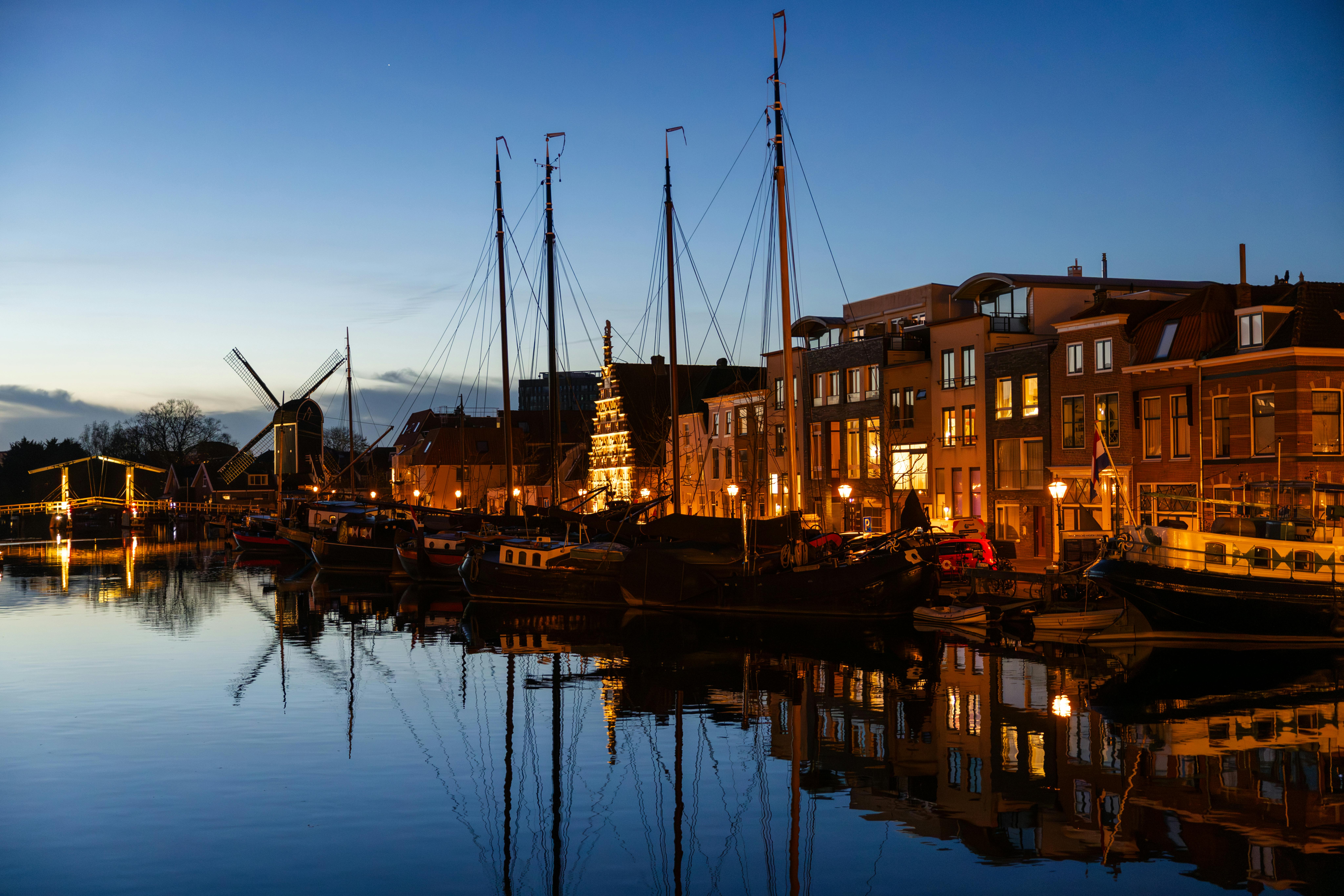 Scenic evening view of Leiden canal with boats and traditional architecture.